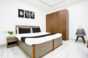 Une chambre à coucher comprenant un lit, une armoire, une table de chevet et une chaise.