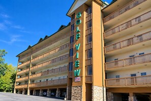 Ett hotell med flera våningar, med en tydlig skylt som visar texten ”COLLEVILLE”, och ett parkeringsgarage under hotellet.