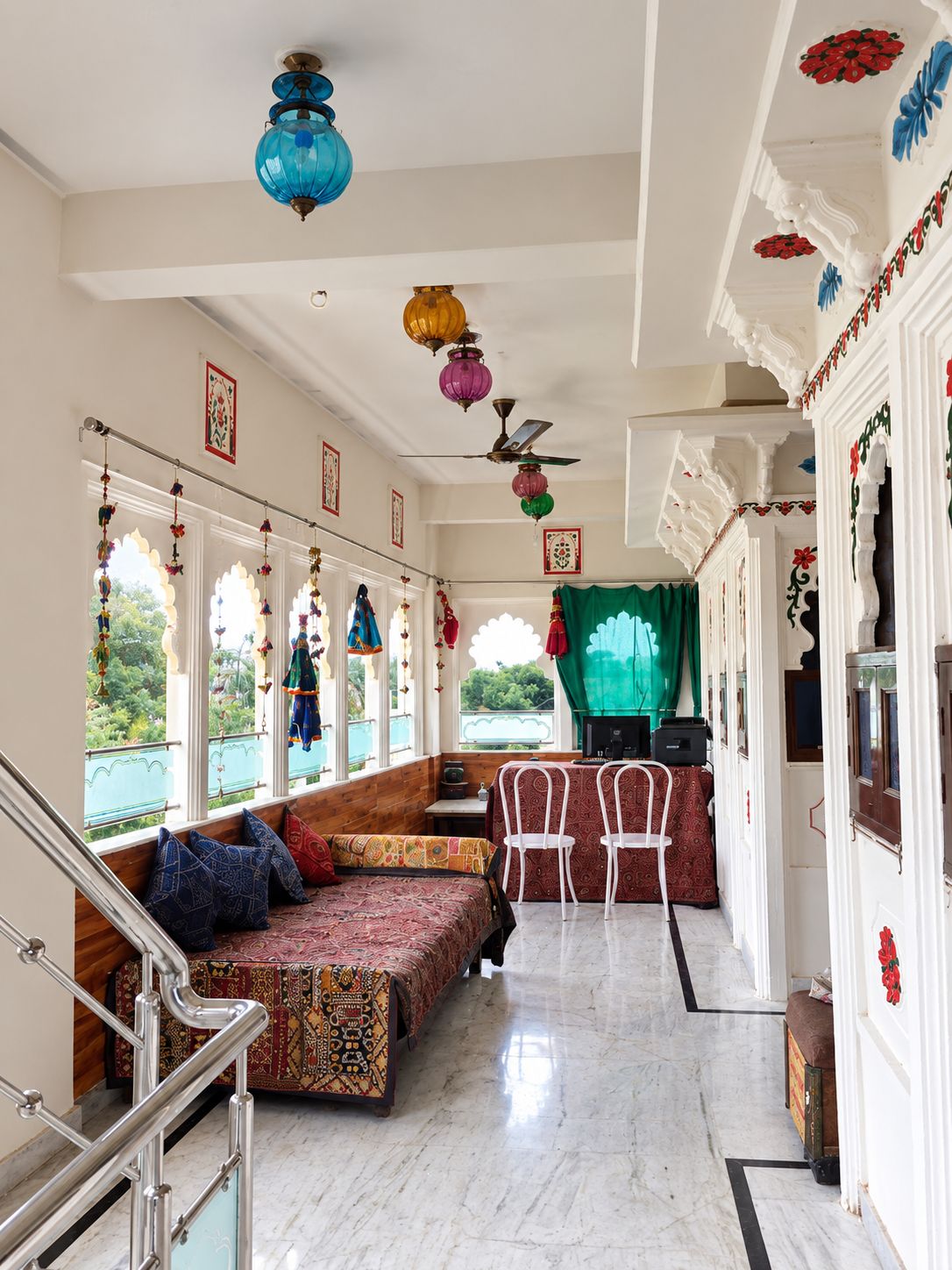 A room with a seating area, a dining table, and a staircase.