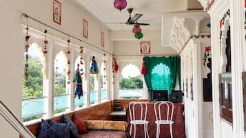 A room with a seating area, a dining table, and a staircase.