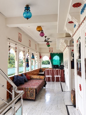 A room with a seating area, a dining table, and a staircase. - The White House By Lake Pichola (Udaipur (M Corp.) (Part))