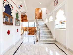 A staircase with marble steps and a wooden wall, leading to a landing with a railing. - The White House By Lake Pichola (Udaipur (M Corp.) (Part))