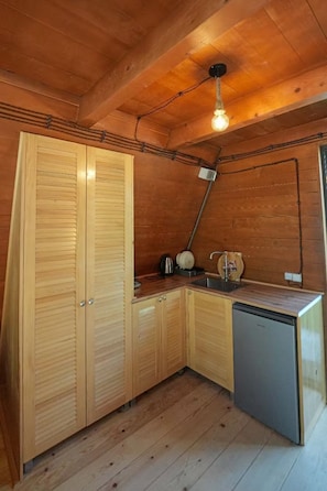 Una cocina funcional con armarios de madera, un lavamanos y un lavavajillas.