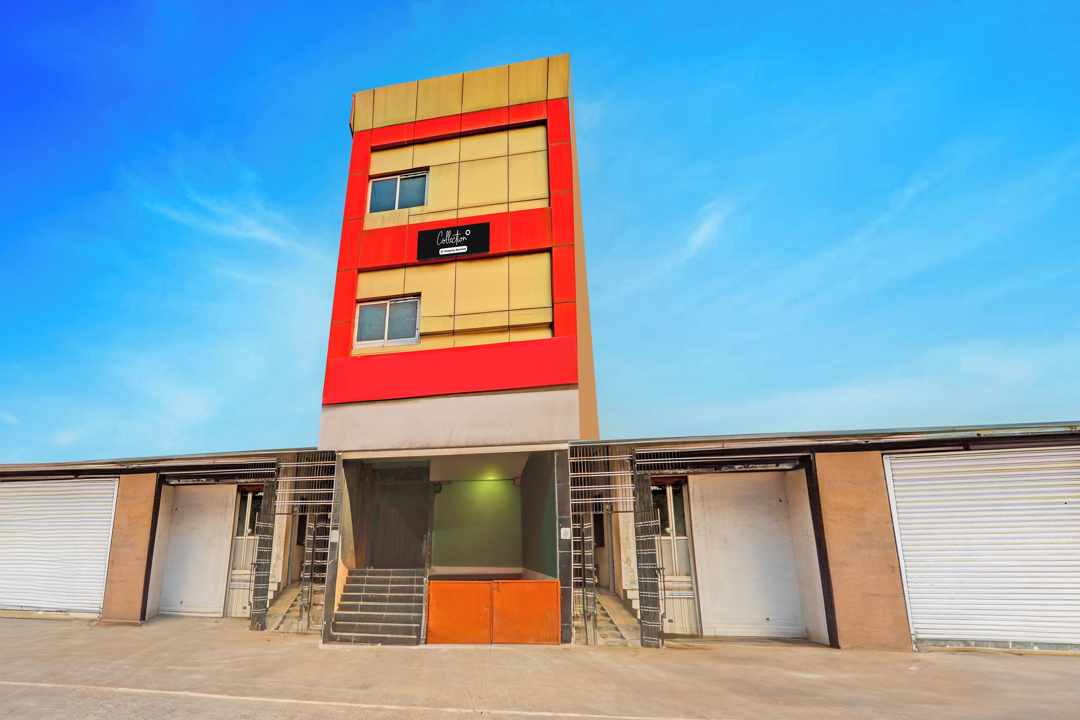 Un edificio de varios pisos con una fachada destacada en rojo y beige, que muestra un cartel que dice 'Collection'.