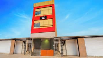 Un edificio de varios pisos con una fachada destacada en rojo y beige, que muestra un cartel que dice 'Collection'.