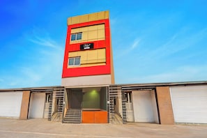 A multi-story building with a prominent red and beige facade, featuring a sign that reads 'Collection.'