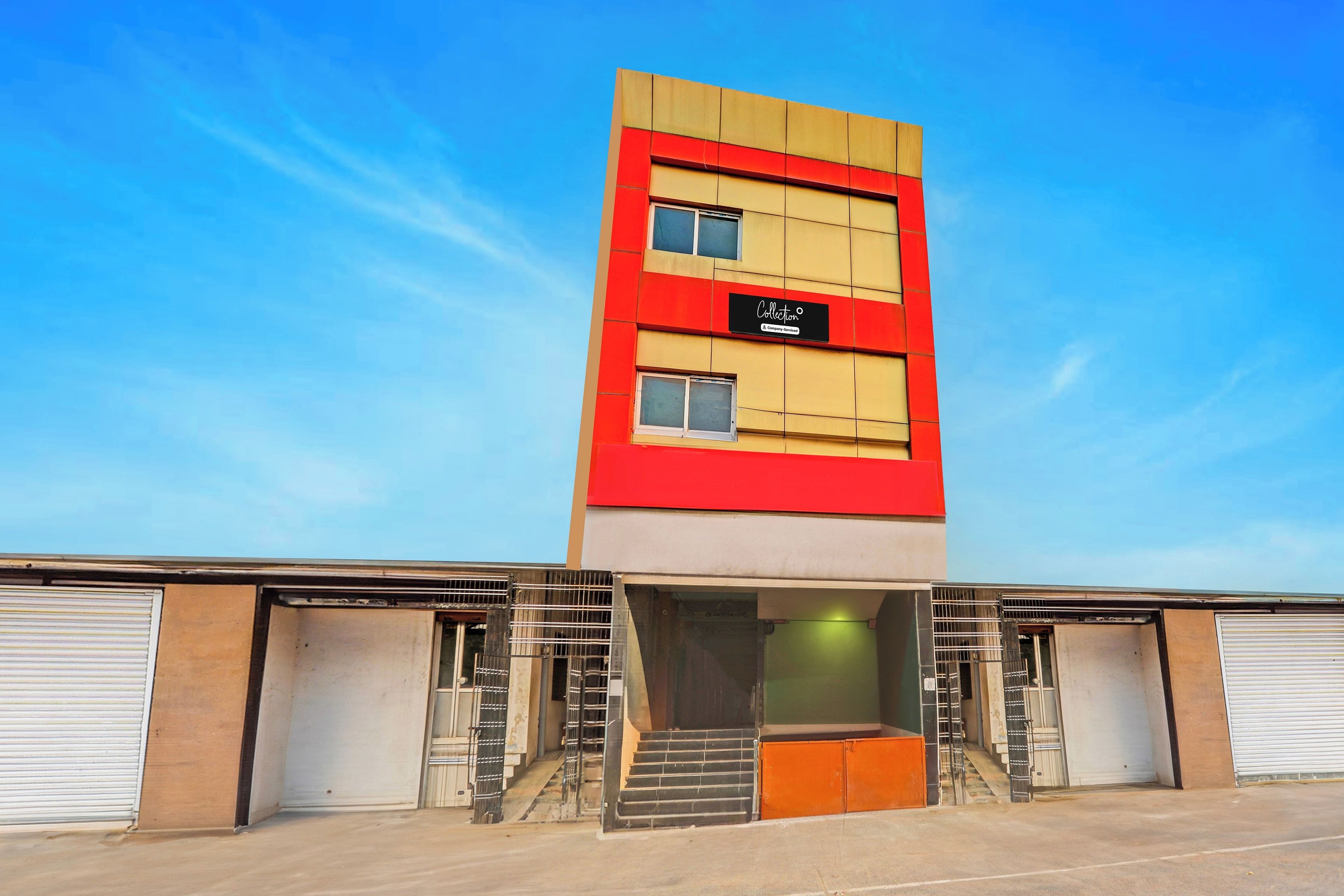 A multi-story building with a red and beige facade, a sign indicating 'Company Services,' and a set of stairs leading to a green-lit entrance.