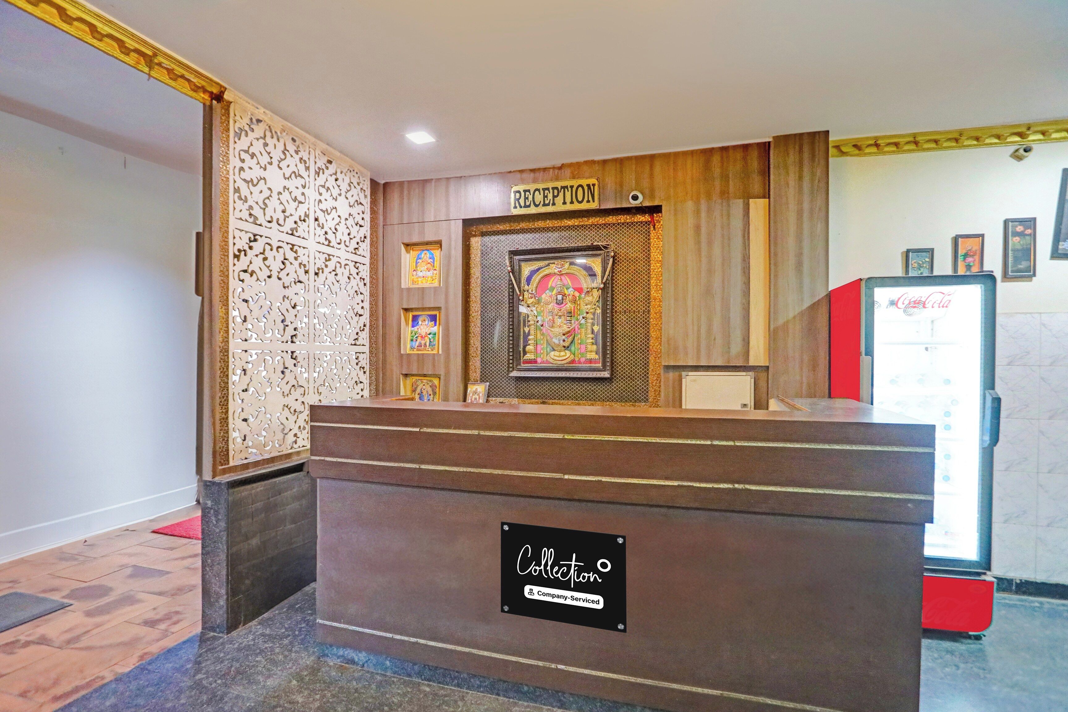 A reception desk with a sign reading 'RECEPTION' above it. There are framed pictures on the wall behind the desk.