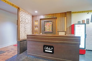 A reception desk with a sign reading 'RECEPTION' above it. There are framed pictures on the wall behind the desk.