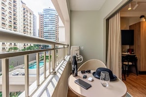 Ein Balkon mit Blick auf hohe Gebäude und einen Swimmingpool.