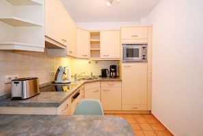 A compact kitchen with a microwave, toaster, and coffee maker. - Nordlicht Vacation Rental in Büsum: Your Fabulous Vacation by the Sea (Büsum)