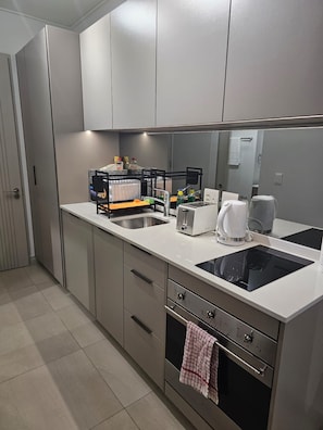 Eine moderne Küche mit einer Spüle, einer Kaffeemaschine, einem Toaster und einem Herd.