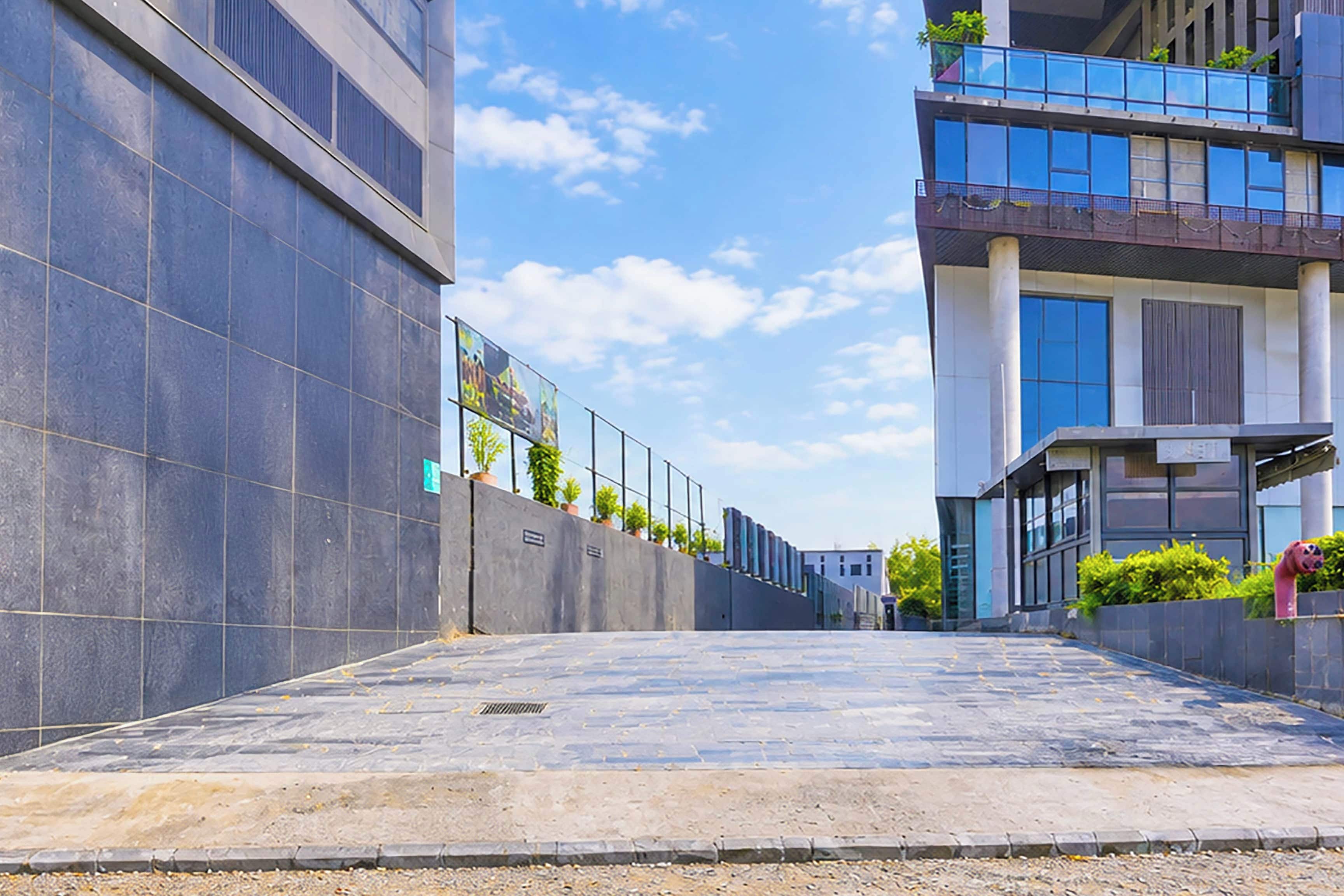 Eine moderne Stadtstraße mit Gebäuden an beiden Seiten, einem klaren Himmel und einem gepflasterten Gehweg.