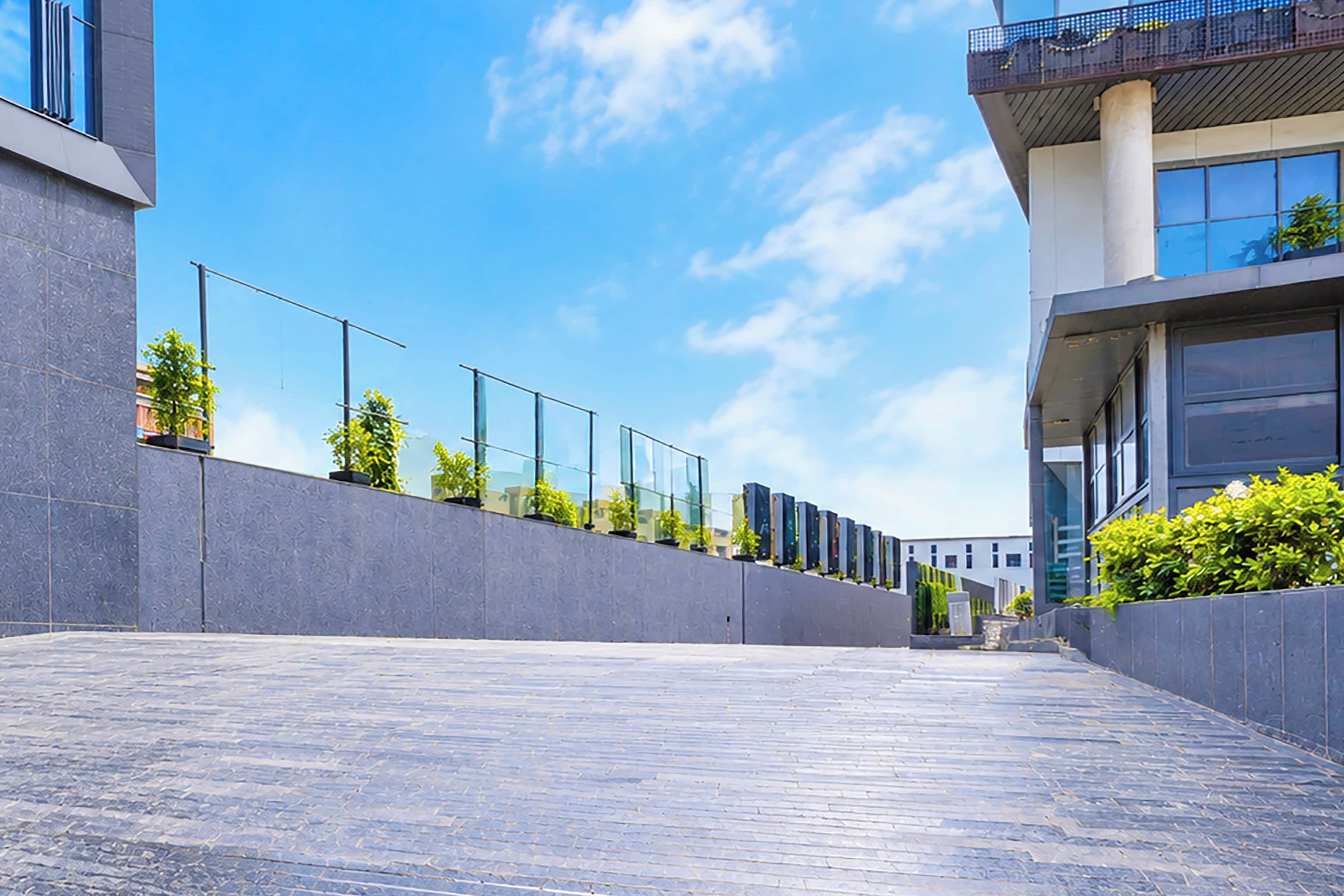Un bâtiment moderne doté d’un toit plat, de grandes fenêtres et d’une allée pavée.
