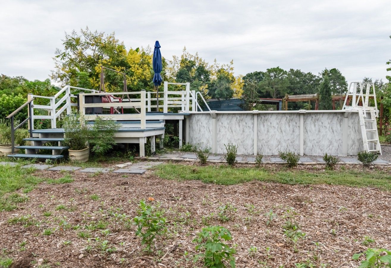 A concrete structure with a ramp and steps, surrounded by a grassy area with small plants.