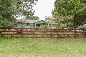 A house with a fenced yard, surrounded by trees and vegetation. - defaultName (Land O` Lakes)