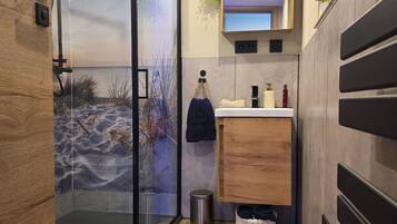 Ein modernes Badezimmer mit Duschkabine aus Glas, einem Holzbadezimmermöbel und einem großen Spiegel.