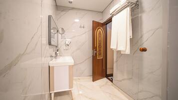 A modern bathroom with a marble floor, a sink, a mirror, and a towel rack.
