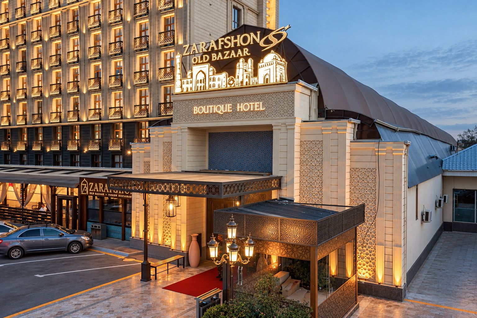 Un hotel con un cartel llamativo que indica 'ZARAFSHON OLD BAZAAR' y 'BOUTIQUE HOTEL', mostrando también un restaurante de fusión.