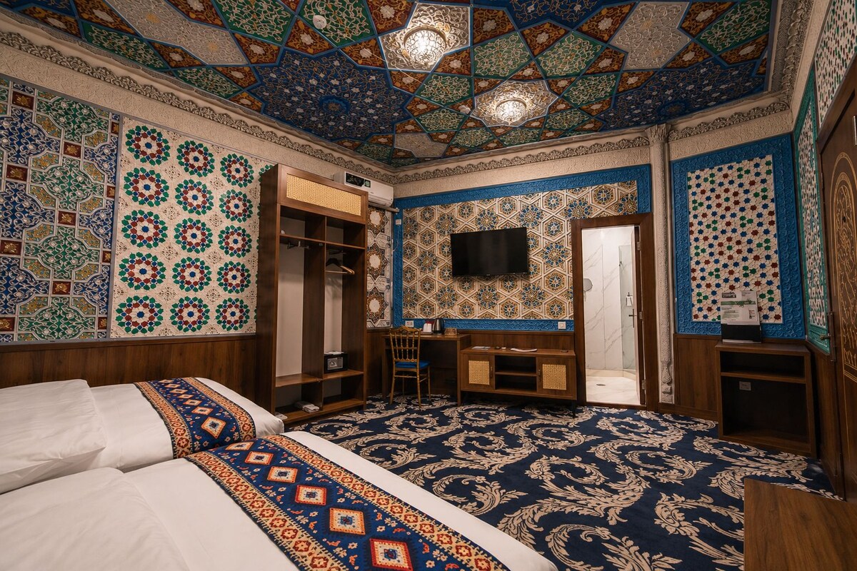 Una habitación con una cama grande, un armario, un escritorio y una ducha.