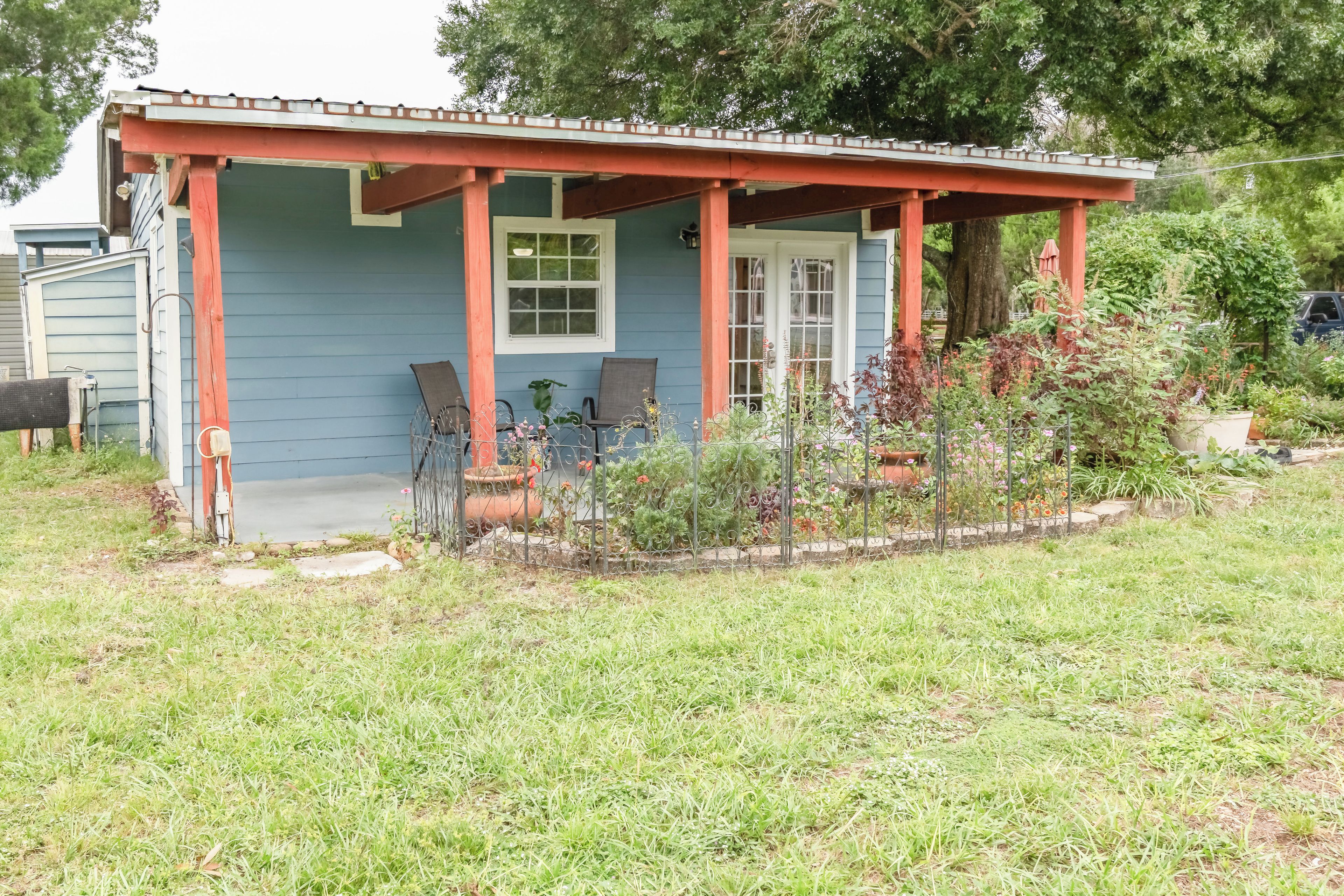 A house with a porch, two chairs, and a potted plant.