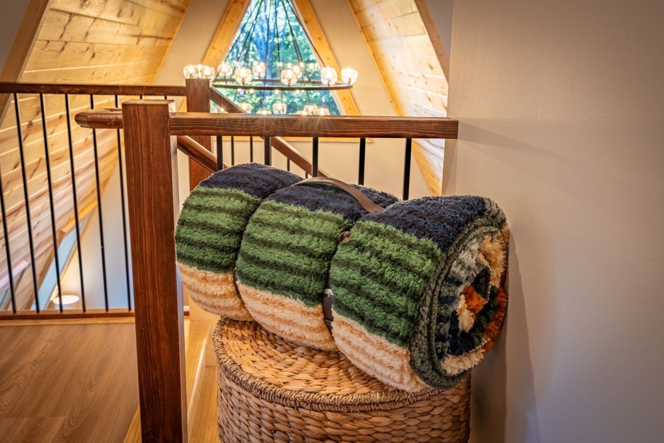 A staircase with a woven basket holding a rolled-up blanket.