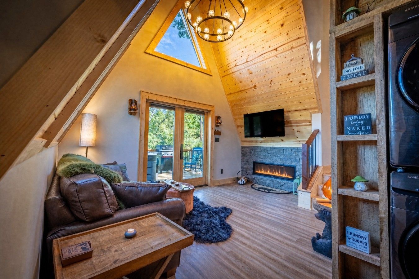 Una camera accogliente in stile loft con camino, televisione e una mensola in legno con cartelli che indicano la lavanderia.