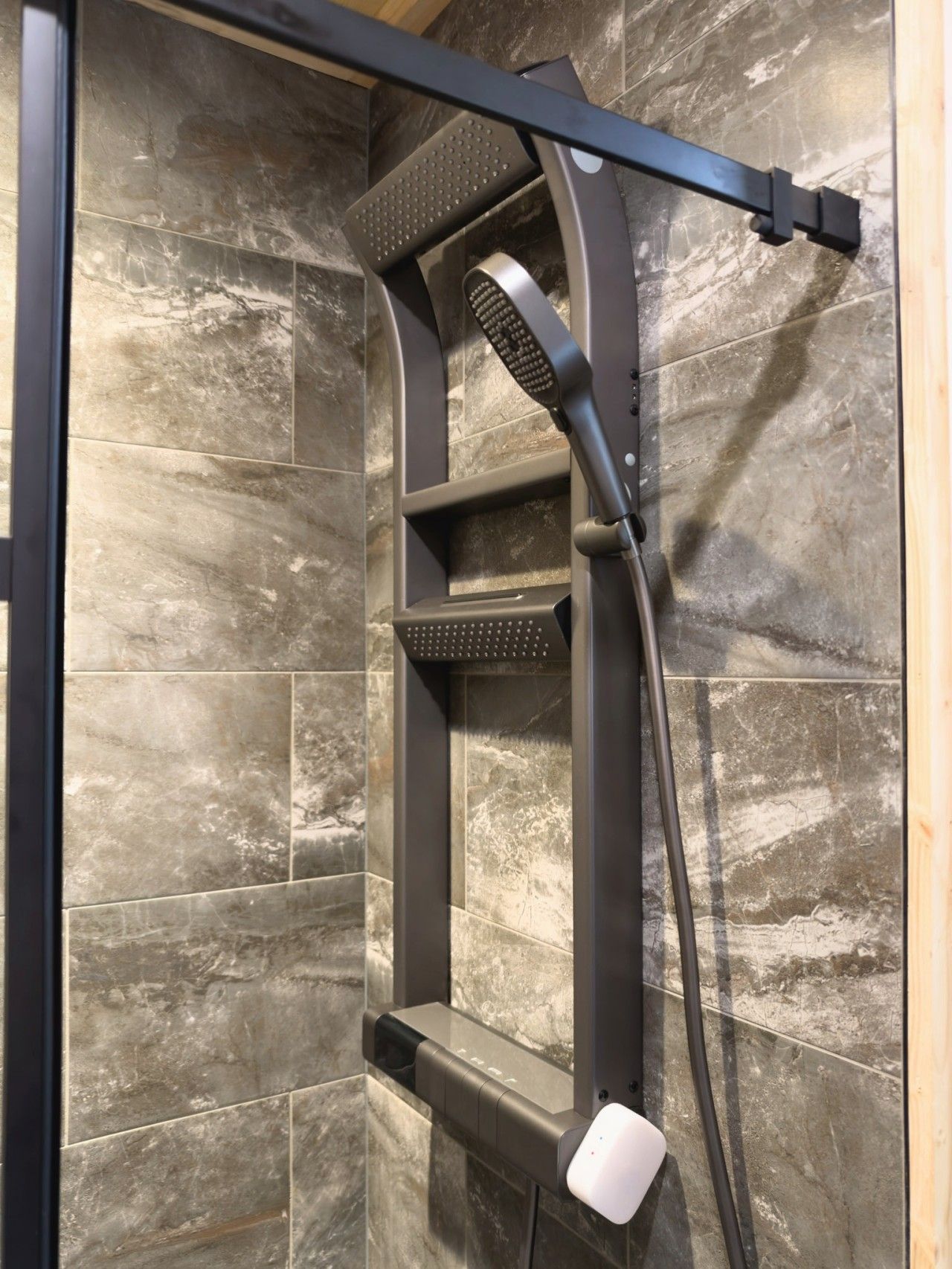 Une cabine de douche équipée d’un pommeau de douche à main et d’une brosse à main.