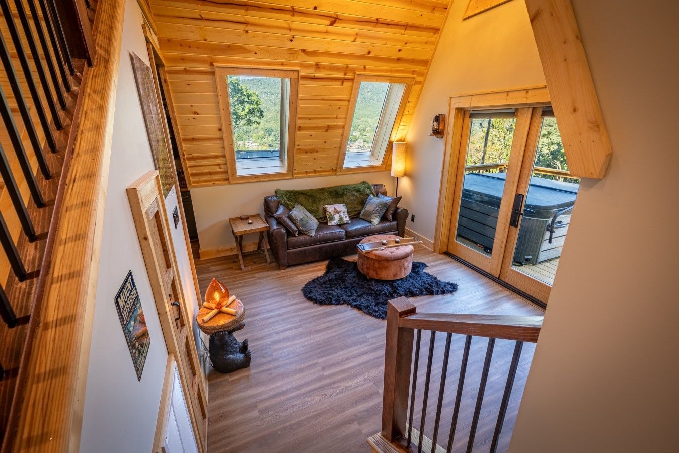 A loft-style room with a wooden ceiling, a sofa, a coffee table, and a view of the outdoors.