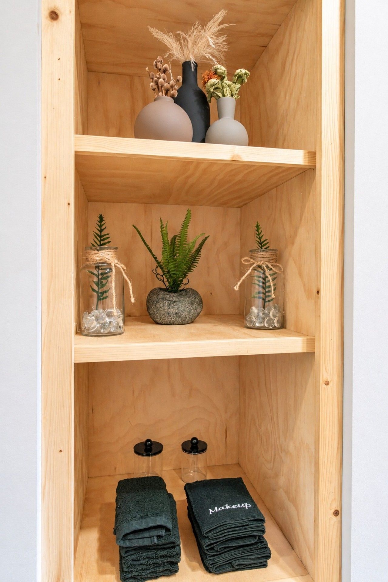 Built-in shelves with towels and decor in the West Jefferson Cabin bathroom.
