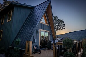 Una casa moderna con tetto spiovente, una terrazza e vista sulle colline.