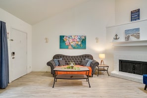 A living room with a fireplace, a sofa, a coffee table, and a painting on the wall. - Lovely 1-bedroom apartment with AC and Wifi in Dallas Pool, Parking, Washer (Dallas)