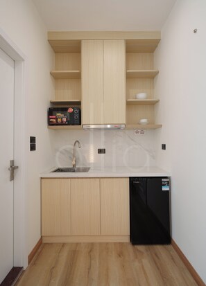 Una cocina compacta equipada con lavavajillas, microondas y horno empotrado.