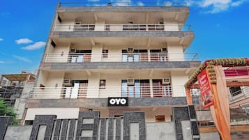A multi-story hotel with balconies, air conditioning units, and a sign for 'OYO'.