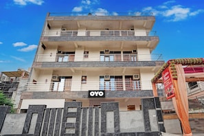 Un hotel de varios pisos con balcones, unidades de aire acondicionado y un letrero que dice 'OYO'.