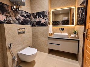 Un bagno moderno con un water, bidet e lavandino.