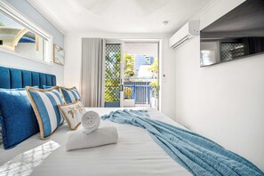 Une chambre d’hôtel avec un lit, une vue sur l’extérieur et un appareil de climatisation.