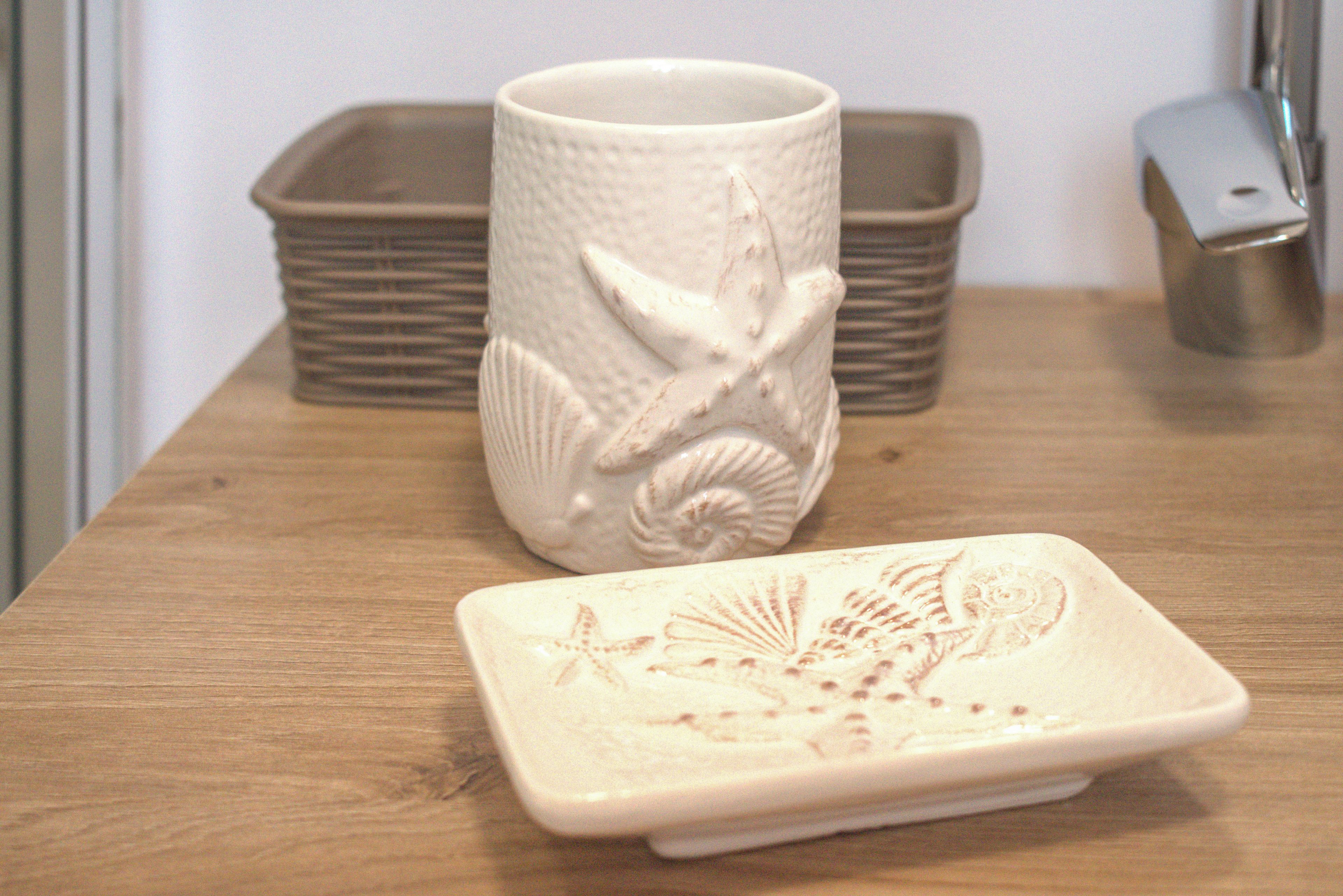 A wooden table with a ceramic mug and coaster.