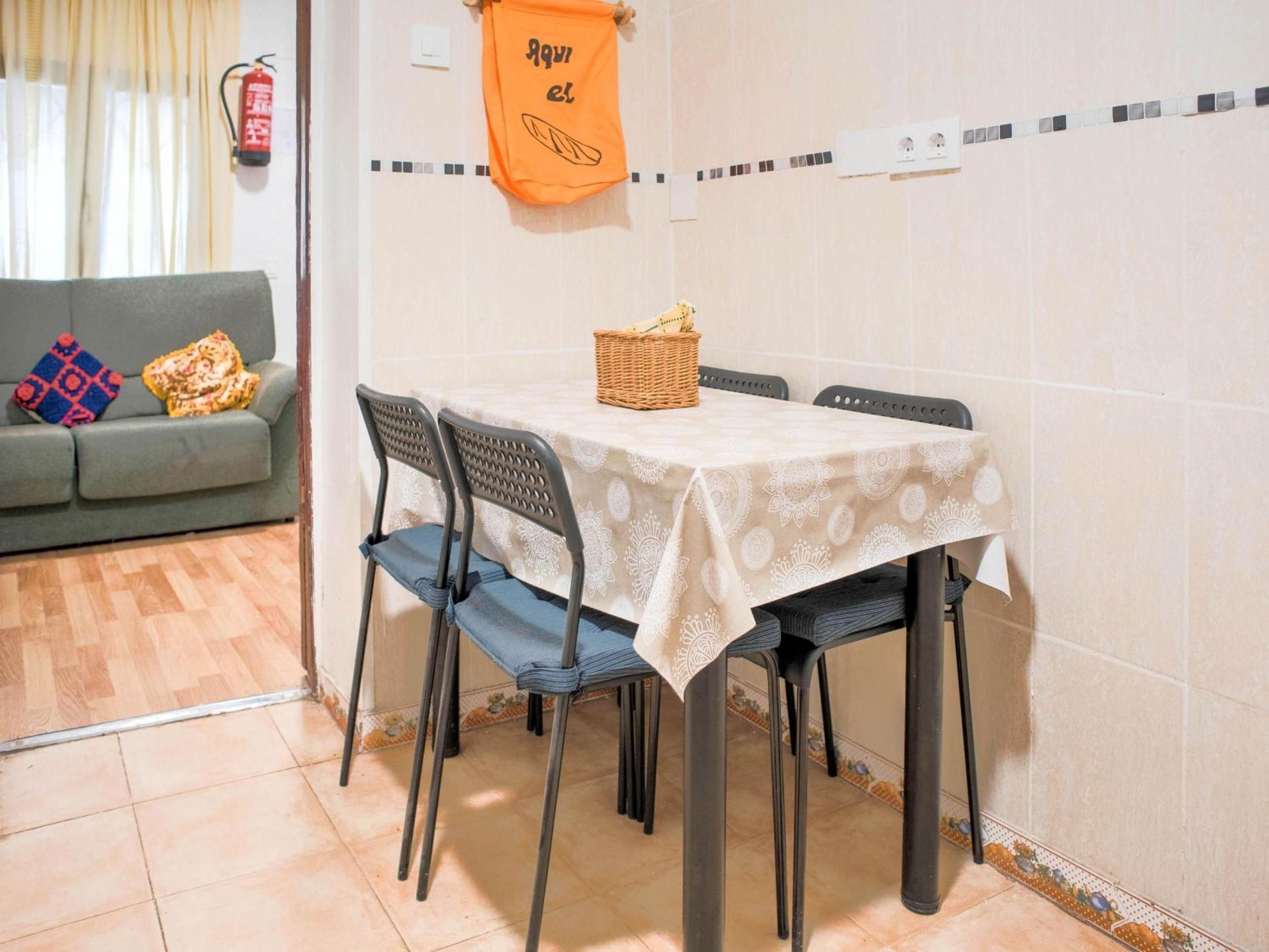 En matplats med ett bord dukat för två personer, stolar, en korg och en brandsläckare på väggen.