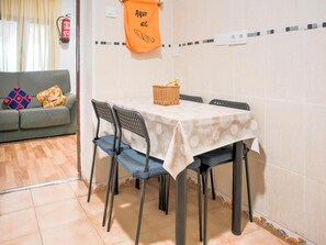 En matplats med ett bord dukat för två personer, stolar, en korg och en brandsläckare på väggen.
