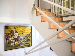 A staircase with a hand-painted mural of a village scene.