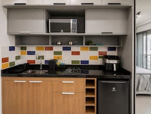 A modern kitchen with a microwave, toaster, and dishwasher. - On Paulista 817 (Vila Mariana)