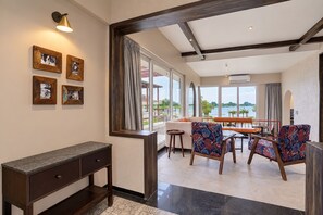 A modern living room with a dining area, large windows, and a view of the outdoors. - The Byke Luxe Astara (Nashik)