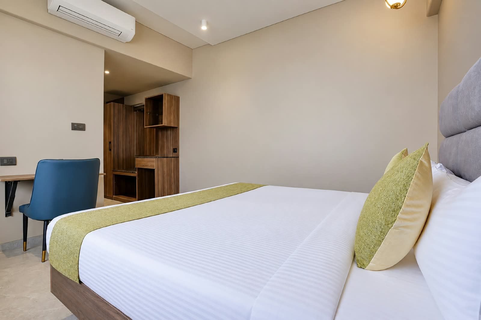 A hotel room with a bed, a desk, and a chair.