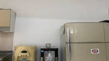 A kitchenette with a refrigerator, a water dispenser, and a microwave.