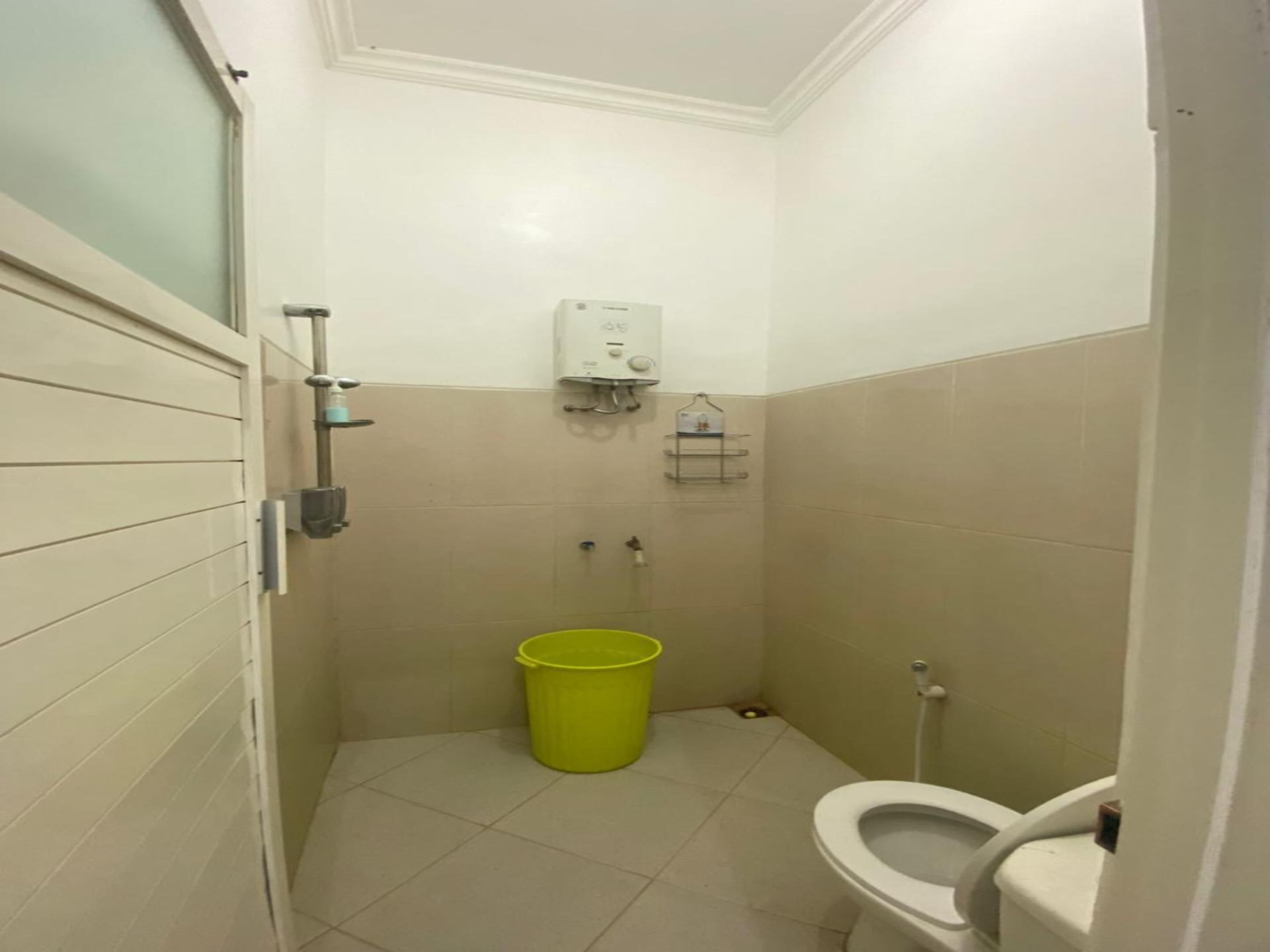 A small bathroom with a toilet, a shower, and a hand dryer.