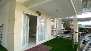 A hotel entrance with a welcome mat, a door labeled 'KAV 5', and a small table with a vase.