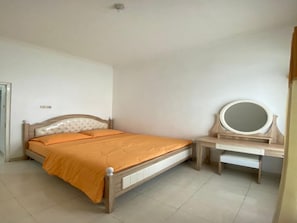 A bedroom with a bed, bedside table, and a mirror. - Cozzy Villa Rizka (Batu)