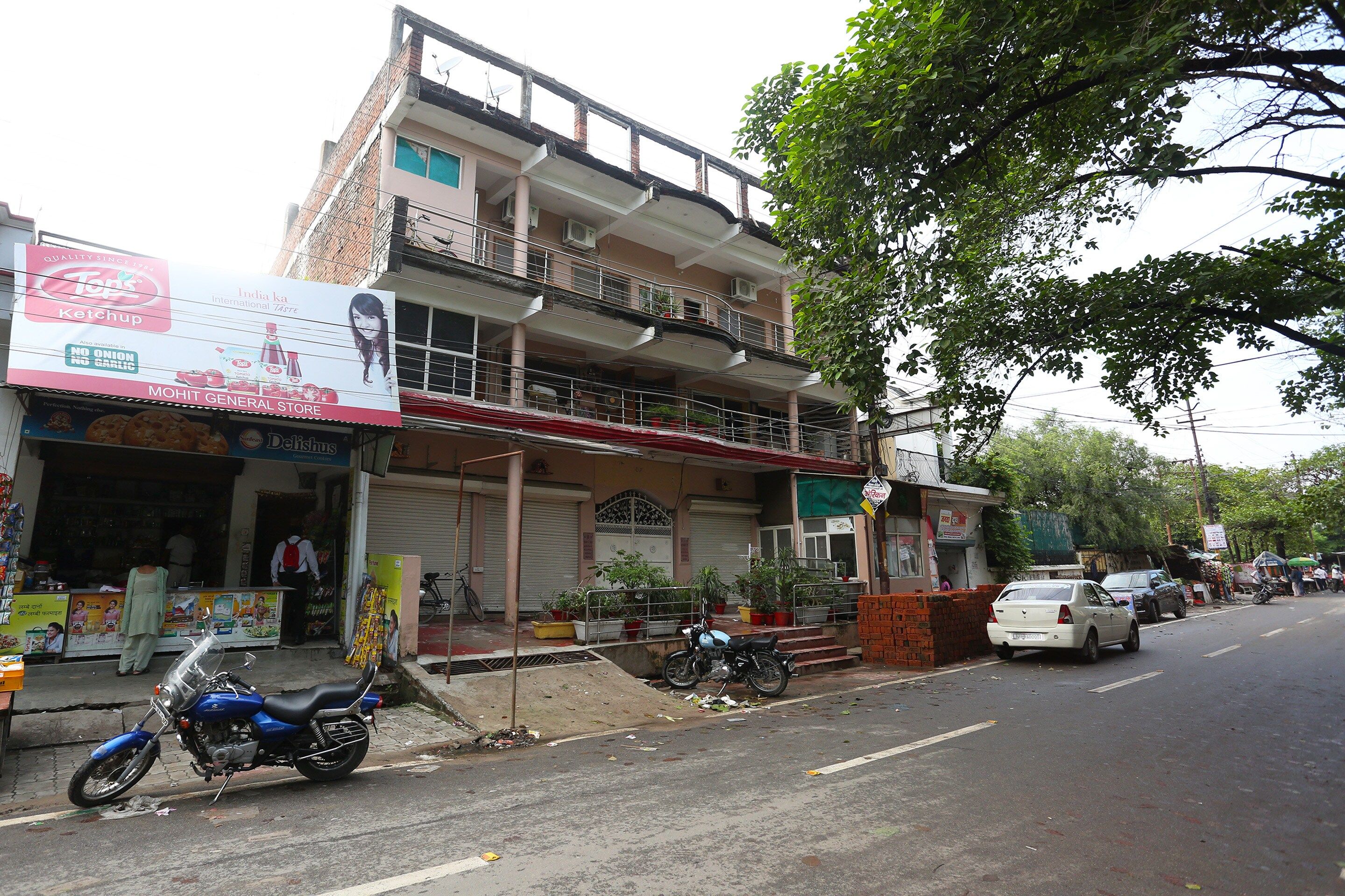 Un edificio de varios pisos con una tienda en la planta baja y un balcón.