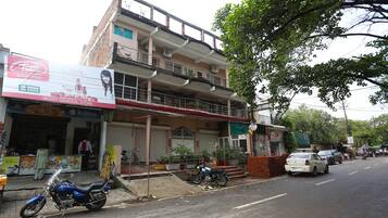 Un edificio de varios pisos con una tienda en la planta baja y un balcón.